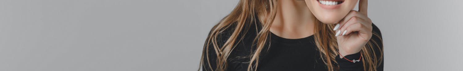 Kvinde med mobiltelefon holder smilende maske op foran sit ansigt